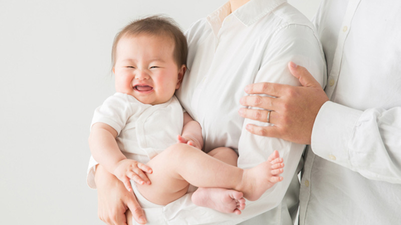 赤ちゃんを抱っこした夫婦の写真